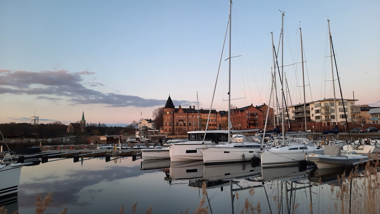 Gästhamnen i Gustavsberg i kvällsljus, med segelbåtar, spegelblankt vatten och Tornhuset.